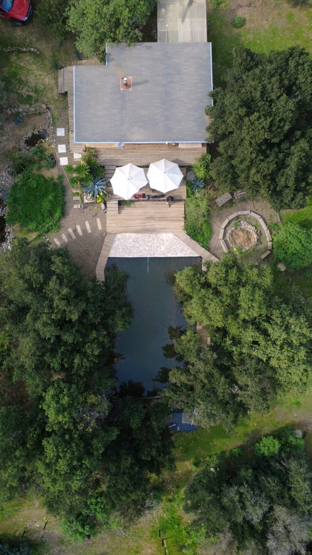 Vista aérea cenital de la casa y la biopiscina