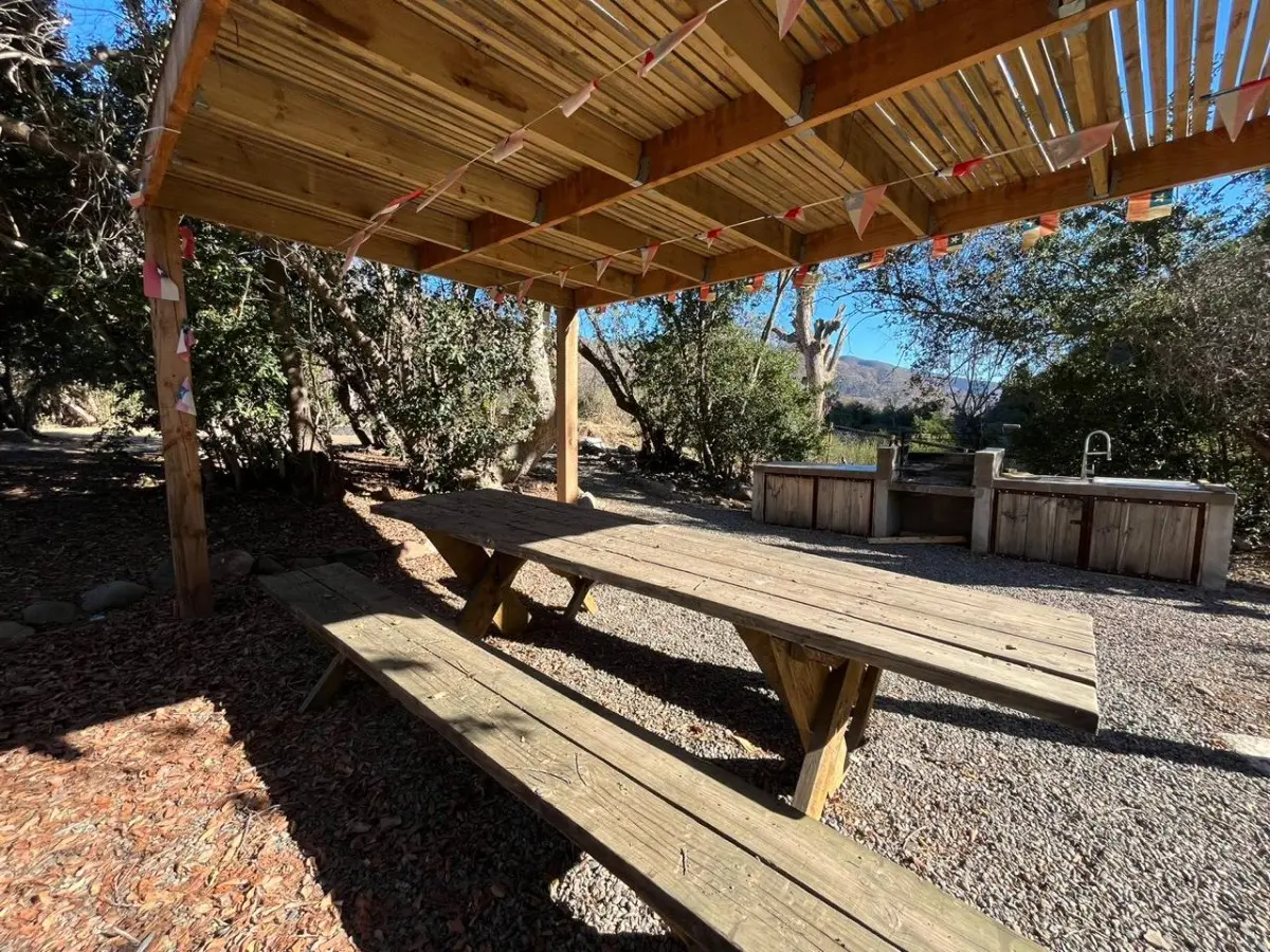 Quincho de madera con mesas y bancas bajo techo